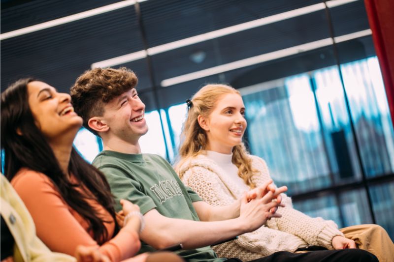 student sitting in an event together smiling